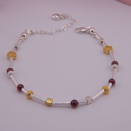 Armband aus Silber mit vergoldeten Elementen und Granat Kugeln